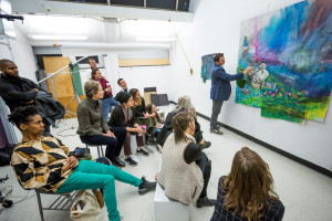 art critique with group of students and a professor at a painting