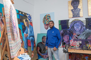 Headshot of Chris Williams, surrounded by paintings