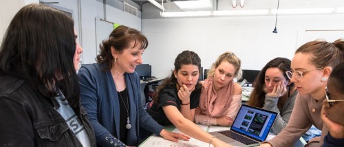 Moore students gathered around a table in an Interior Design class.