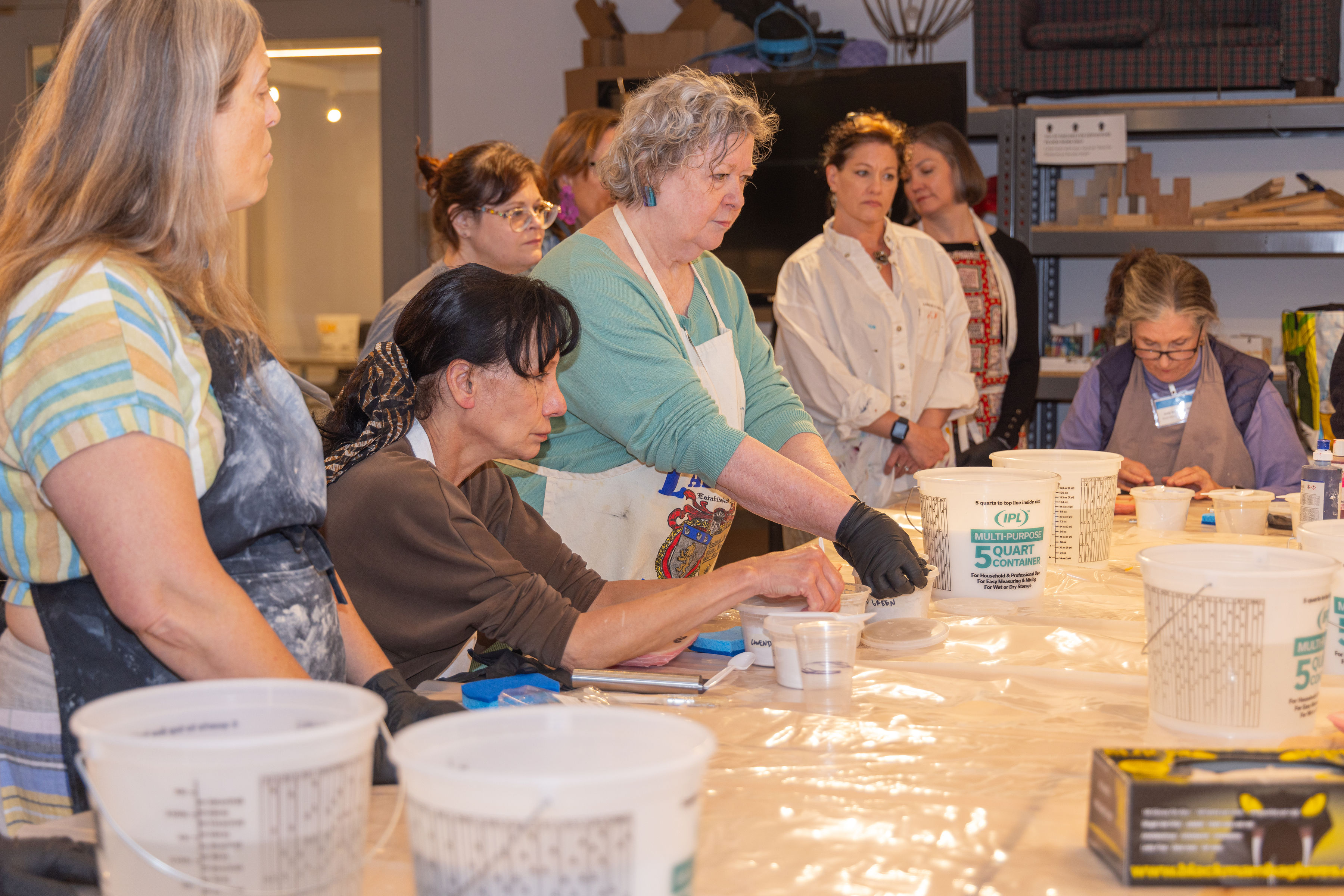 Group of alumni in a classroom participating in a hands-on plaster casting workshop