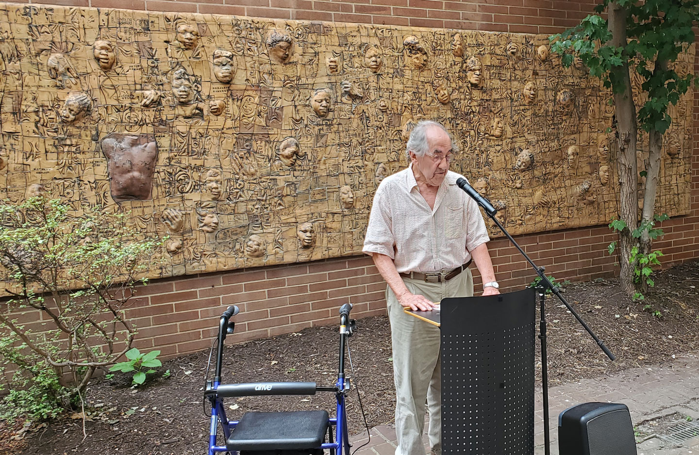 Photo of John Costanza speaking in front of his Black Lives Matter mural at the dedication in the Moore Galleries courtyard