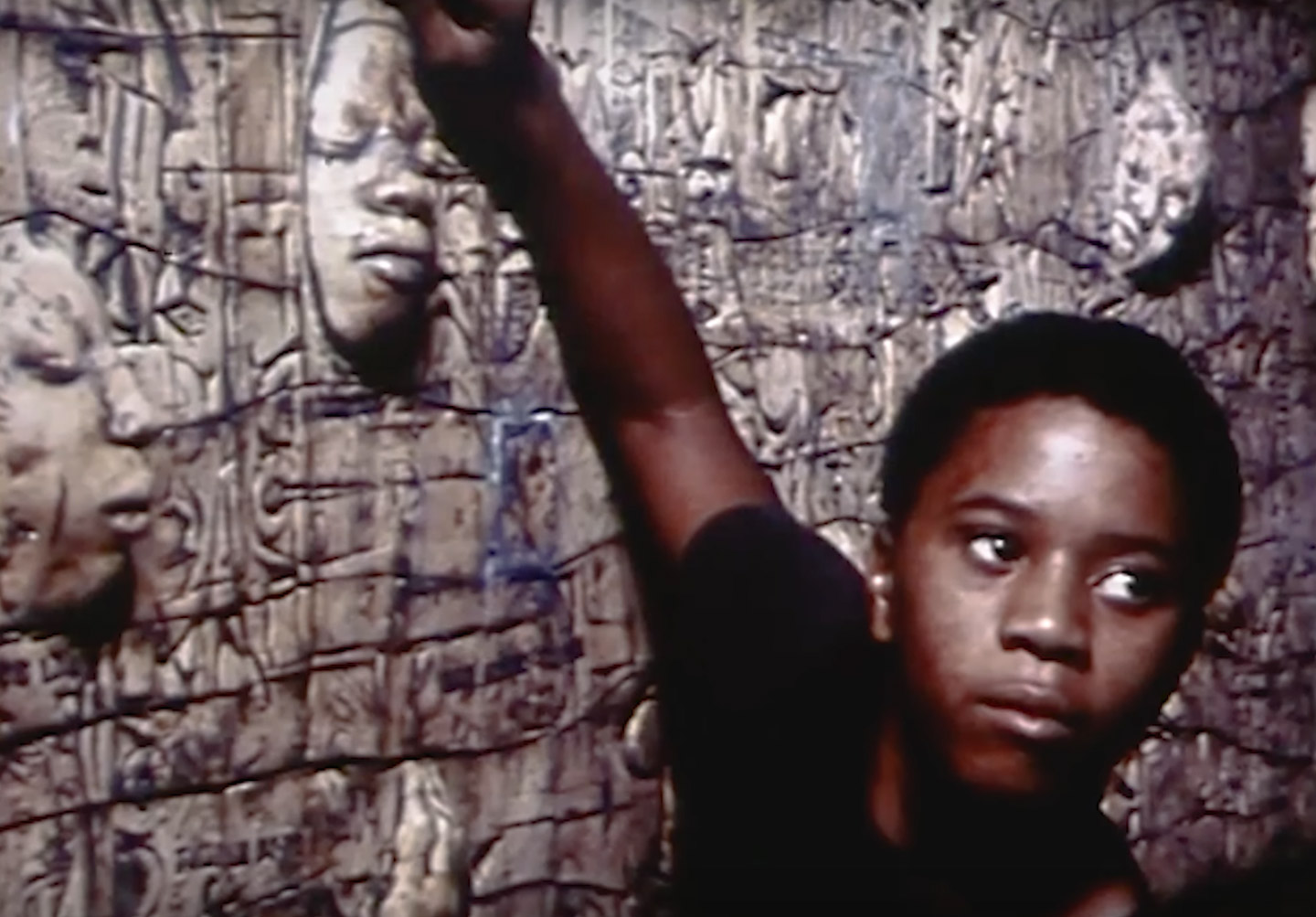 Screenshot of a young Black boy standing in front of John Costanza's Black Lives Matter Mural