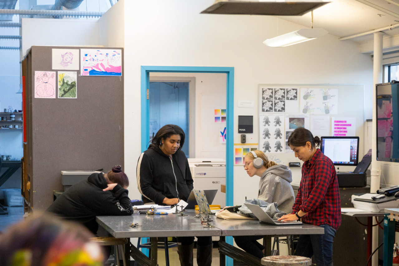 Students and a professor working in a fine art studio