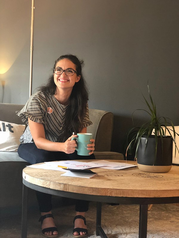 Tyler Shea holding a mug and smiling at her internship at Push10