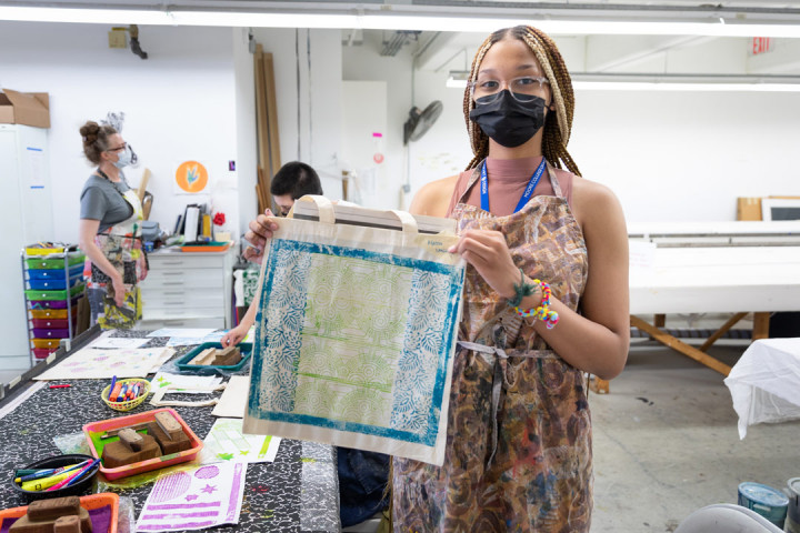 A SADI 2021 student showing her artwork on a tote bag at the Fabric Workshop and Museum