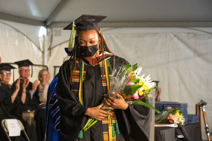 A photo of Laila Islam receiving flowers at the podium