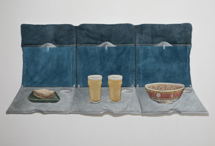 Photo of Kay Healy's soft sculpture Fabric Objects with a sandwich, two glasses of beer and a bowl of soup on a couch