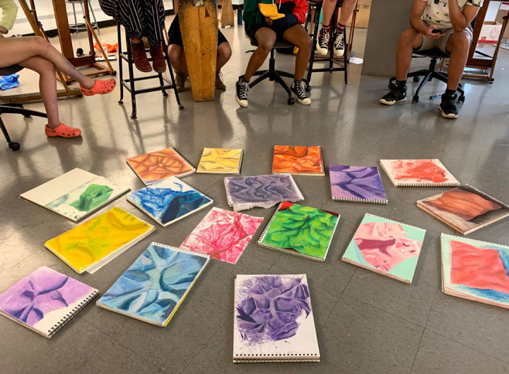 YAW student paintings displayed on the ground for review